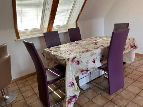 un tavolo con sedie viola e una tovaglia floreale di Gut und Günstig nähe Hamburg a Uetersen
