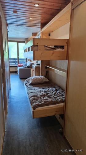 Ce lit superposé se trouve dans un dortoir doté d'un canapé. dans l'établissement Joli appartement situé à l'entrée du Val Claret, à Tignes