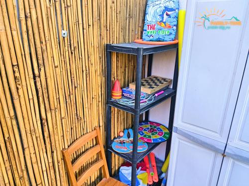 a black shelf with toys on it next to a chair at Family-TIME בית פרטי לנופש משפחתי באילת in Eilat