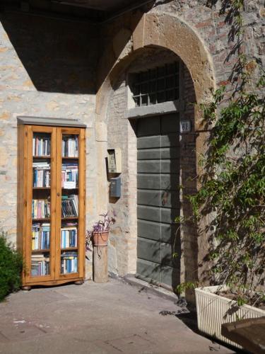 a building with a wooden door with books at Agriturismo Le Case di San Vivaldo in Montaione
