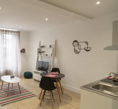une cuisine avec une table, des chaises et un évier dans l'établissement STUDIO HELSINKI - Style et Modernité, à Charleville-Mézières