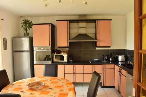 La cuisine est équipée d'une table, d'un réfrigérateur et d'un four micro-ondes. dans l'établissement Maison de charme avec jardin à Courtils, proche du Mont Saint-Michel, à Courtils