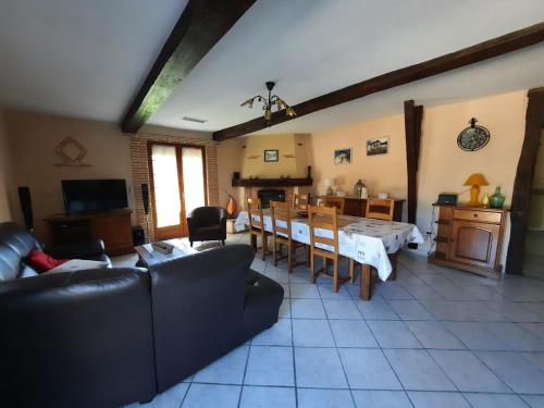 un salon avec un canapé et une table dans l'établissement Gîte de Maurin campagne, à Marguestau