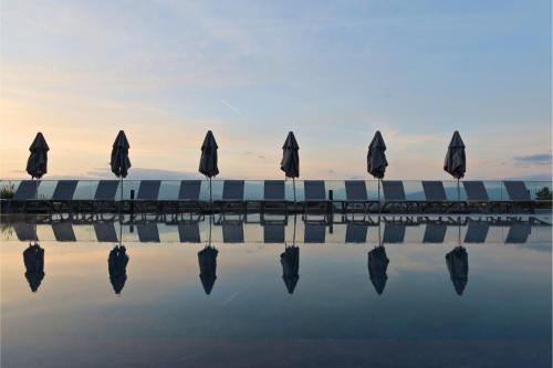 a group of umbrellas sitting next to the water at Everness Hotel & Resort in Chavannes-de-Bogis
