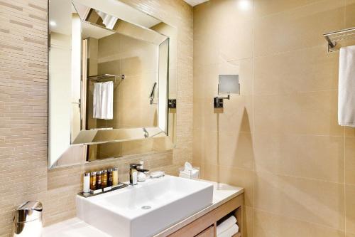 a bathroom with a white sink and a mirror at Ikos Olivia in Gerakini