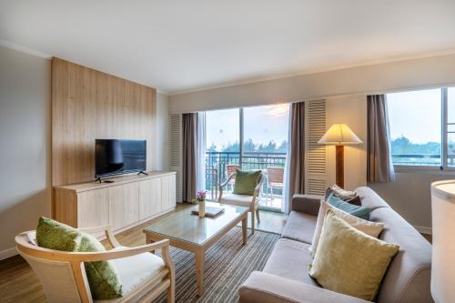 a living room with a couch and a tv at Kantary Bay Hotel And Serviced Apartment Rayong in Rayong
