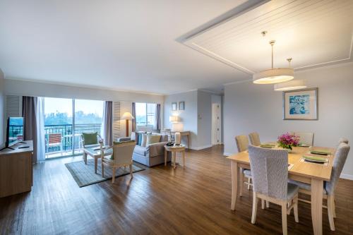 a dining room and living room with a table and chairs at Kantary Bay Hotel And Serviced Apartment Rayong in Rayong