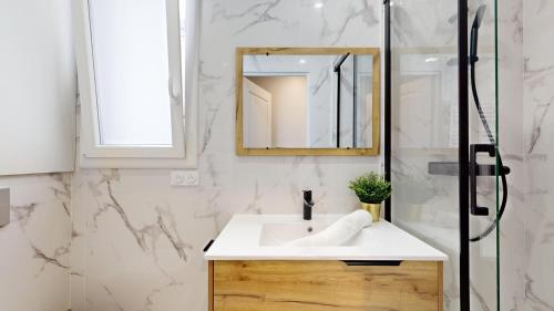 une salle de bain avec un lavabo blanc et un miroir dans l'établissement Bluestay 196 - Charmant Appartement au Marais, à Paris