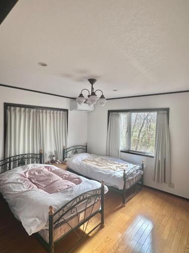 two beds in a room with two windows at リサの家 in Nasu-yumoto