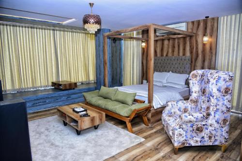 a bedroom with a bed and a couch and a chair at Vilasini Inn in Maddūr