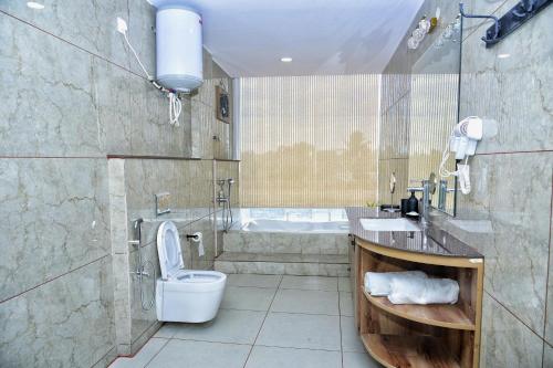 a bathroom with a toilet and a sink and a tub at Vilasini Inn in Maddūr