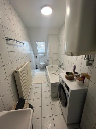 a white bathroom with a sink and a stove at Charmante Altbauwohnung in Erlangen