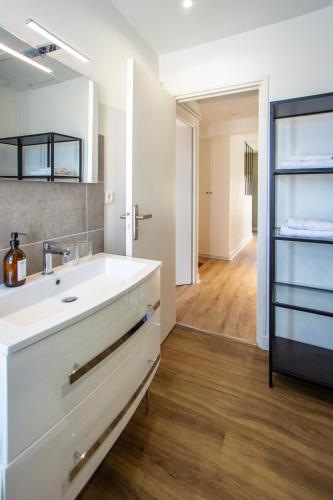 une salle de bain blanche avec un lavabo et un miroir dans l'établissement Appartement entier - Centre historique, à Angoulême