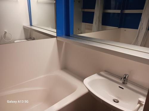 une salle de bain blanche avec un lavabo et un miroir dans l'établissement Appartement duplex 4 pers à Arc 1800, balcon, Wi-Fi, accès pistes et commerces à proximité - FR-1-411-912, à Bourg-Saint-Maurice