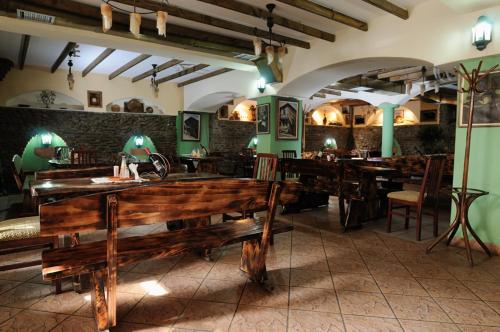 un restaurante con bancos de madera y mesas en una habitación en Hotel Premier Centar, en Bitola
