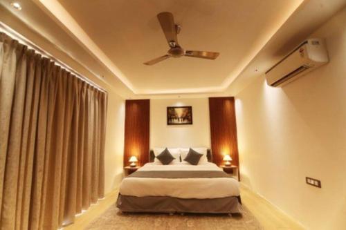 a bedroom with a bed and a ceiling fan at Qubes Farmhouse Near Manesar in Manesar