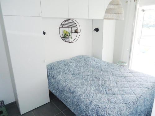 une chambre avec un lit avec une couette bleue dans l'établissement Bel Appartement climatisé à 500m des plages de sable et des commerces, à Cavalaire-sur-Mer