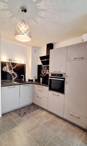  La cuisine est équipée de placards blancs et d'un réfrigérateur. dans l'établissement Bel Appartement climatisé à 500m des plages de sable et des commerces, à Cavalaire-sur-Mer