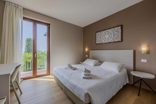 a bedroom with a large bed and a large window at Residence San Michele in Costermano sul Garda