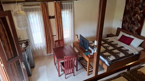 a bedroom with a bed and a desk and a table at Alamanda Family Villas, Pool & Local Tours in Yogyakarta