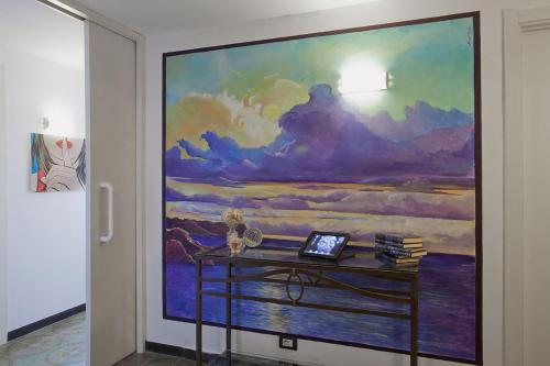 een schilderij aan de muur van een kamer met een bureau bij Bed & Breakfast Cas'Alda in Varazze