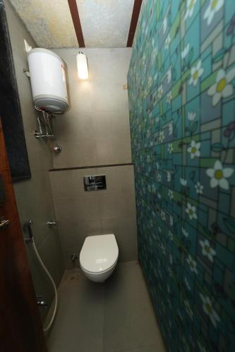 a small bathroom with a toilet and a sink at Bougain Villa Resort Park By Dream Villas in Pune