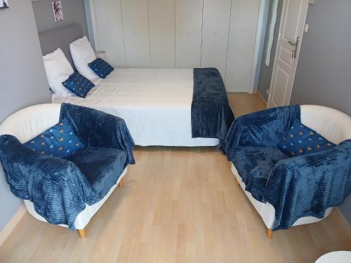 a bedroom with a bed and two chairs in it at Chez Bernard et Nicole in Betton