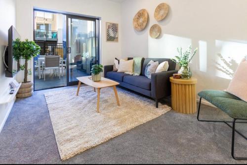 a living room with a couch and a table at 3 Minutes walk to Riverside Market 4bed4bath in Christchurch