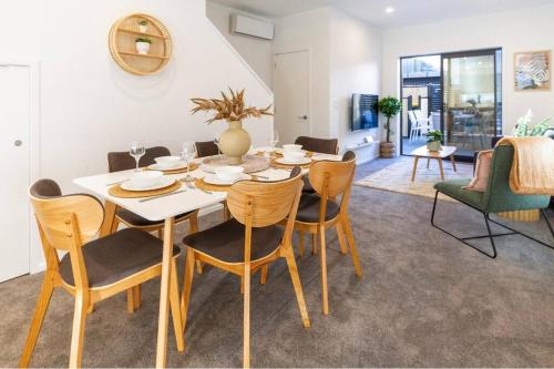 a dining room with a white table and chairs at 3 Minutes walk to Riverside Market 4bed4bath in Christchurch