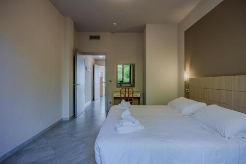 a bedroom with a large white bed with towels on it at Residence San Michele in Costermano sul Garda