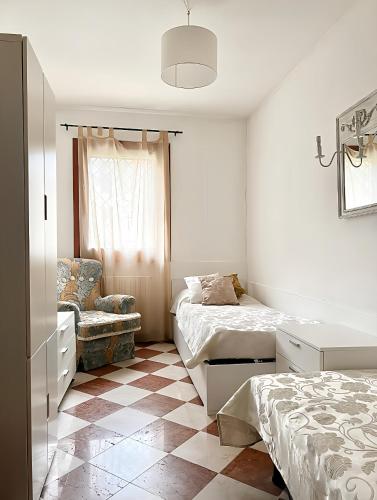 a bedroom with two beds and a chair at Venice Secret Garden view in Venice