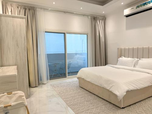 a bedroom with a bed and a large window at Beautiful private villa with pool in Dubai