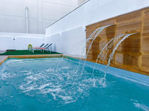 a pool with a water fountain in a room at Beautiful private villa with pool in Dubai
