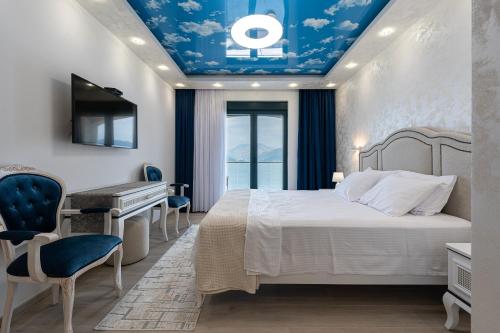 a bedroom with a bed with a blue ceiling at Villa Sonja Apartments in Krasici