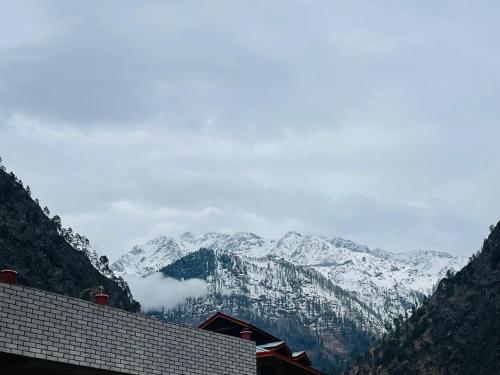 a view of a mountain range with snow covered mountains at Trippy Homestay in Kasol