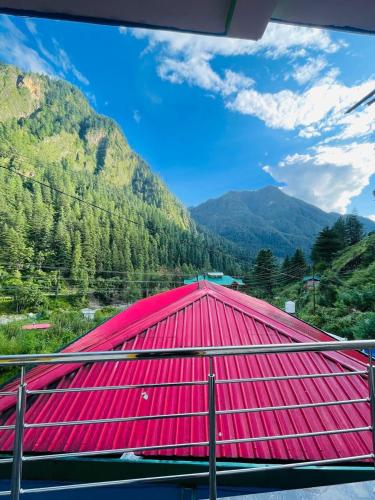 a red roof with a mountain in the background at Trippy Homestay in Kasol
