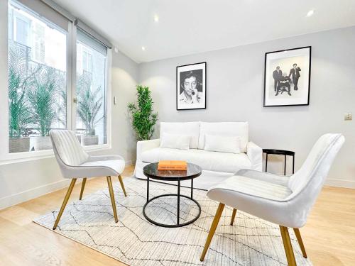 - un salon avec un canapé blanc et deux chaises dans l'établissement Deluxe apartment near the Tour Eiffel, à Paris