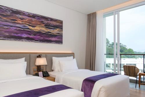 a hotel room with two beds and a window at Marianna Resort And Convention Tuktuk - Samosir, Marclan Collection in Tuk Tuk