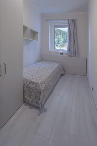 a white room with a bed and a window at Residence San Michele in Costermano sul Garda