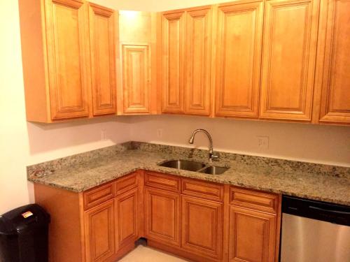 a kitchen with wooden cabinets and a sink at DC International Hostel 2 in Washington, D.C.