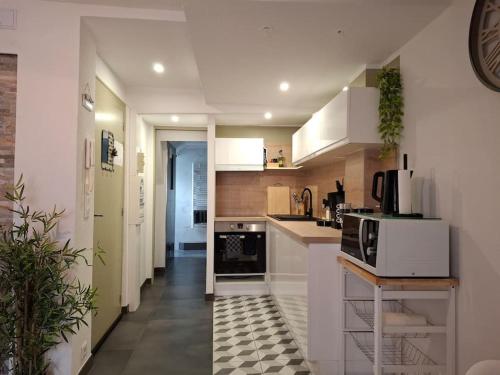 une cuisine avec des armoires blanches et des appareils noirs dans l'établissement Bel Appartement, Sélestat, à Sélestat