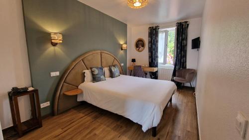 Thorigné-sur-DuéにあるHôtel Saint Jacquesの大きな白いベッドと青い枕のある寝室