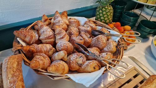 a basket full of pastries and bread on a table at Hôtel Saint Jacques in Thorigné-sur-Dué