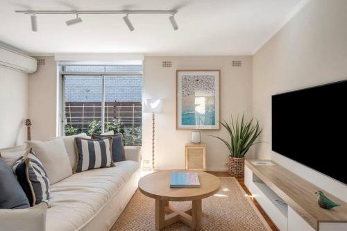 a living room with a couch and a large tv at Luxe-Coastal Balmoral Townhouse in Sydney