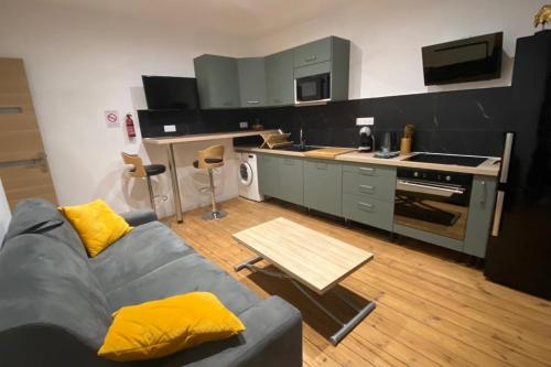 un salon avec un canapé et une cuisine dans l'établissement 19B - Le Bastille a cosy apartment in a great location, à Tulle