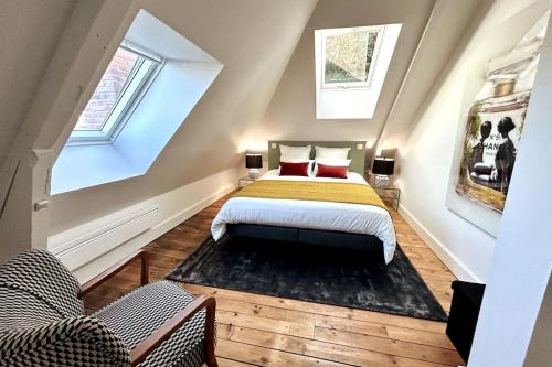 - une chambre mansardée avec un lit et deux chaises dans l'établissement Casa Clemenceau #1, #2, #3 et #4 - T2 très haut standing - Climatisation - Centre Ville, à Brive-la-Gaillarde