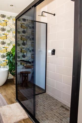 a shower with a glass door in a bathroom at Villa 183 in Roodekrans