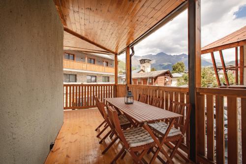 a wooden porch with a table and chairs on a deck at La Maison Mestia in Mestia