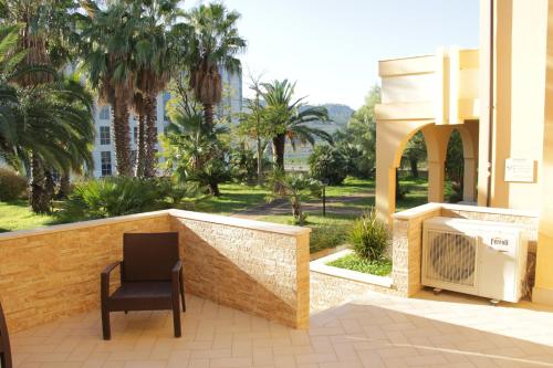 a chair and a television on a patio with palm trees at San Michele Apartments&Rooms in Catanzaro