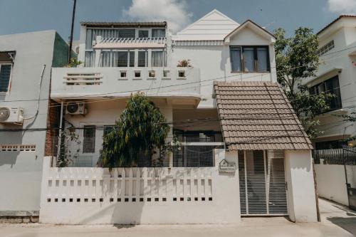 a white house with a white picket fence at Nhà Bơ Homestay in Phan Rang